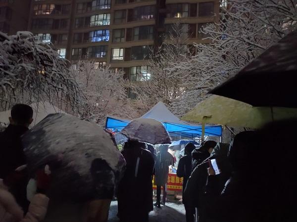 河南郑州：雪夜核检白衣暖绿城  寒风卖菜保供惠民生