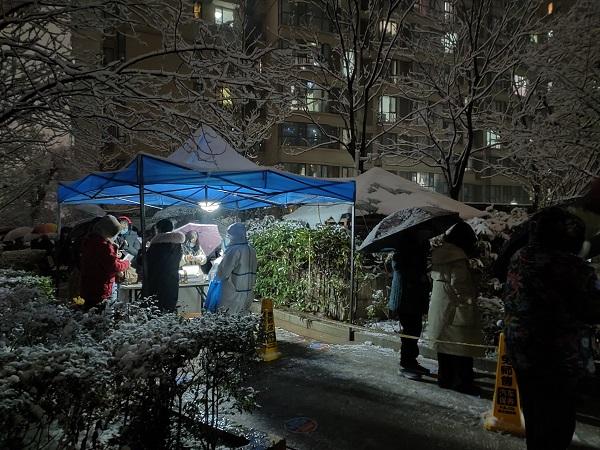河南郑州：雪夜核检白衣暖绿城  寒风卖菜保供惠民生